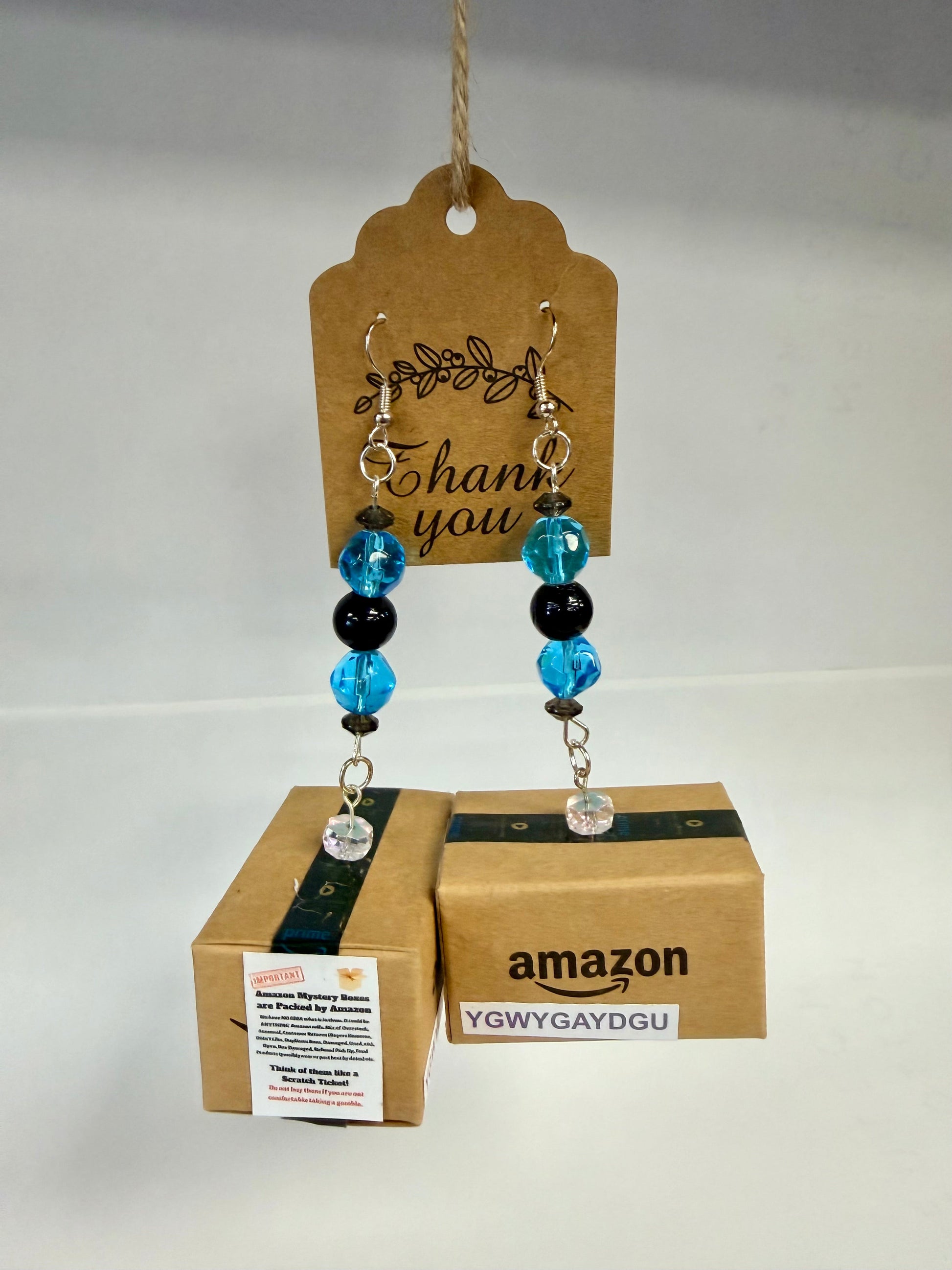 Handcrafted miniature Amazon mystery box earrings close-up